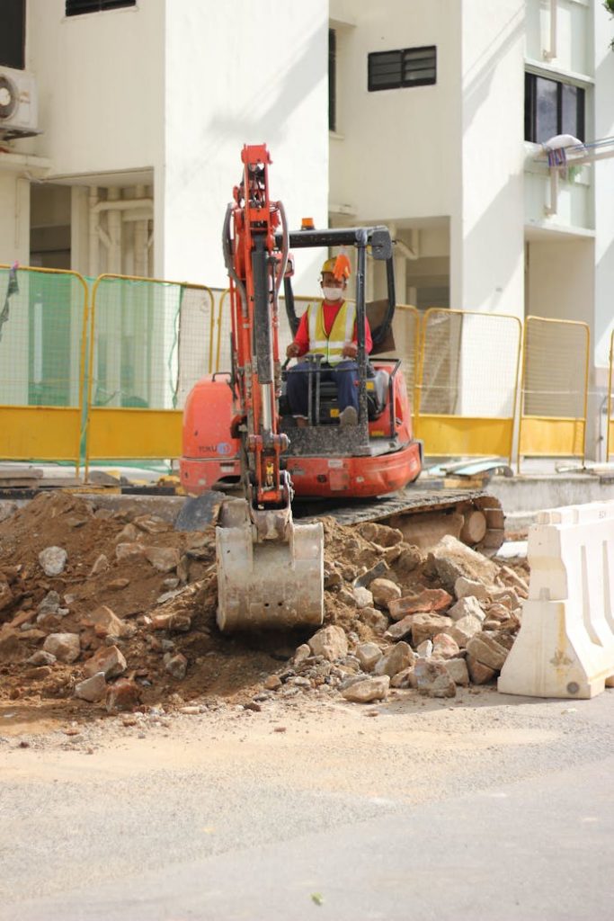 pexels-photo-6548201 A construction worker operates a backhoe during a building project in an urban area.